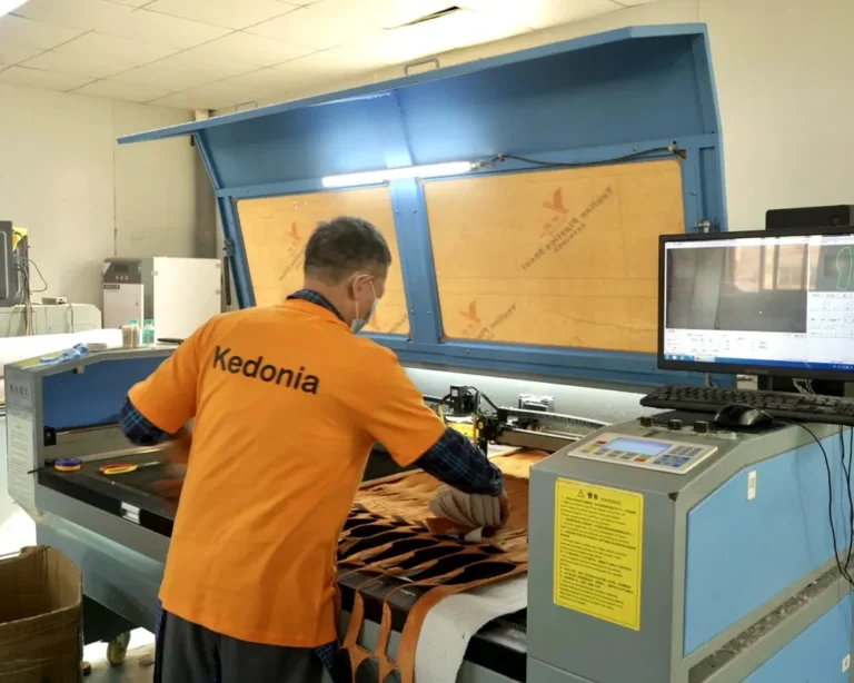 Production support operator preparing custom plush fabric panels on cutting equipment