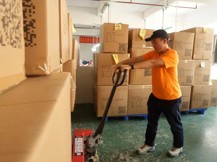 Quality control team moving finished plush cartons for inspection before delivery
