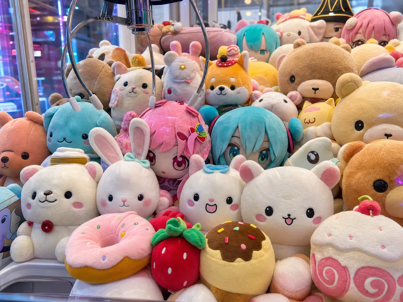 Close-up of a Japanese claw machine packed with kawaii plush prizes and anime characters